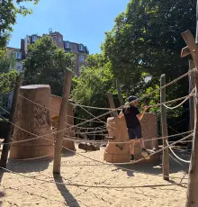 Kind klettert auf dem Spielplatz neben der Werkstatt
