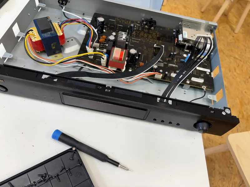 Zerlegter Receiver mit Schraubendreher auf der Werkbank